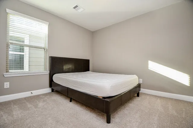 a view of a livingroom with a ceiling fan & windows