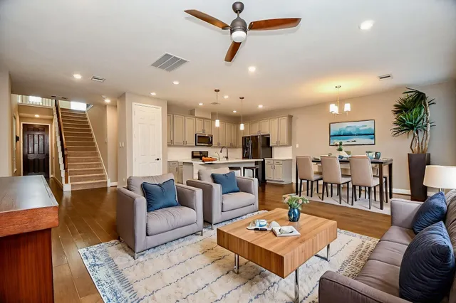 a kitchen with stainless steel appliances kitchen island granite countertop a stove top oven a sink and a refrigerator