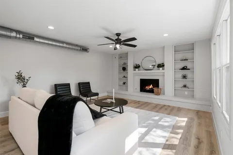 a living room with furniture a fireplace and a chandelier