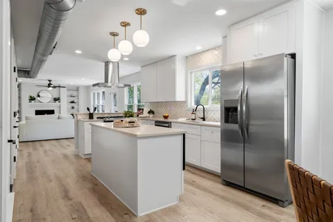 a kitchen with kitchen island a counter top space cabinets and stainless steel appliances