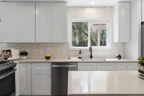 a kitchen with a sink appliances and cabinets