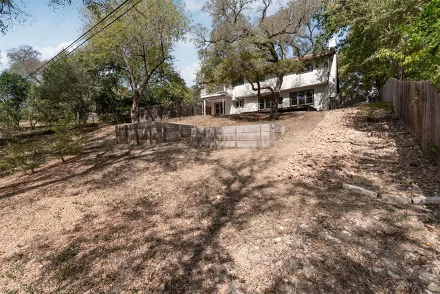 a view of a yard with a bench and trees