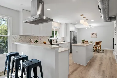 a kitchen with a table chairs microwave and cabinets