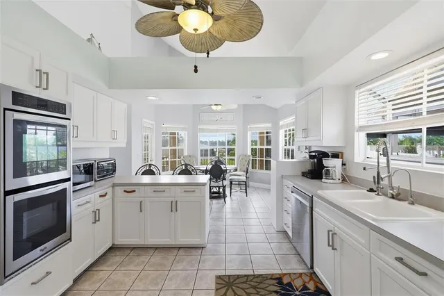 a open kitchen with stainless steel appliances a stove a sink cabinets and living room view