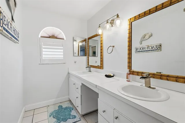 a bathroom with a double vanity sink window and mirror