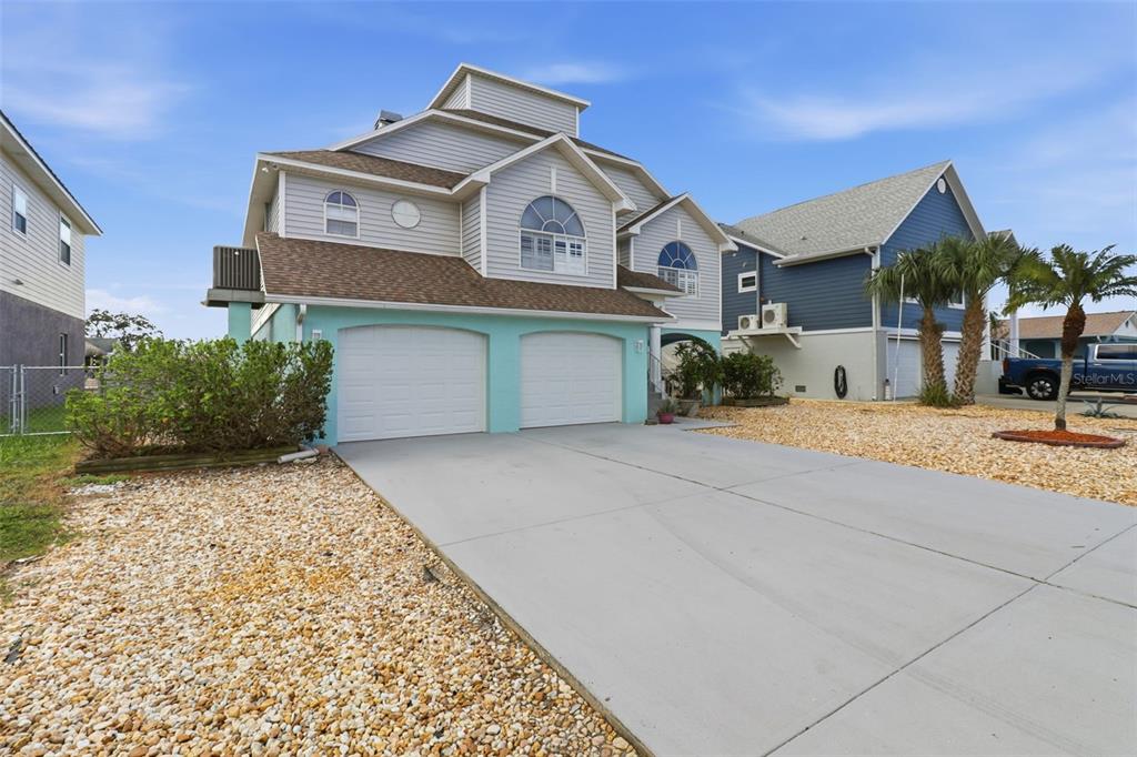 7324 Islander Lane Hudson, FL 34667 - Photo 3 of 35 a front view of a house with a yard and garage