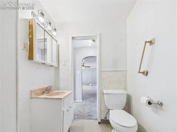 a bathroom with a granite countertop toilet sink and mirror