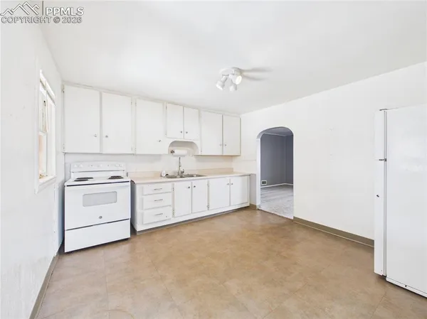 a kitchen with white cabinets and white appliances