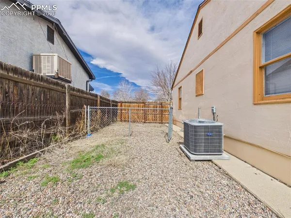 a backyard of a house with barbeque oven and wooden fence