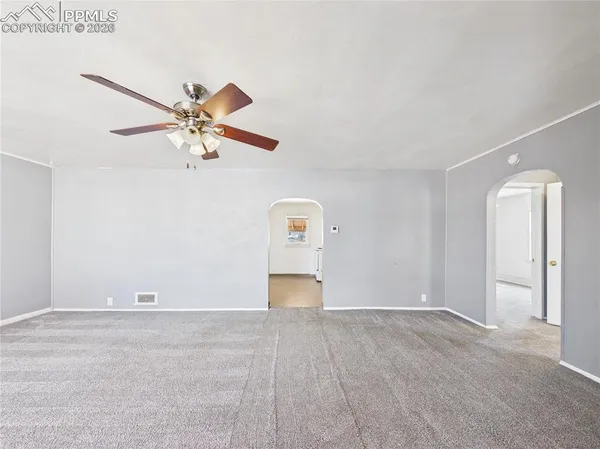 an empty room with closet and fan