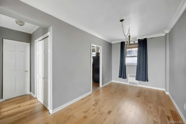 a view of a hallway with wooden floor and chandelier