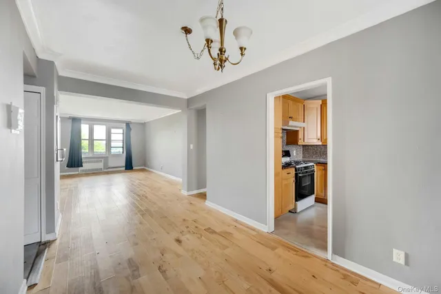 a view of a hallway with wooden floor and a living room