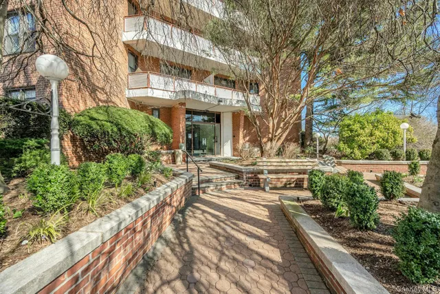 a view of a building with large trees and plants
