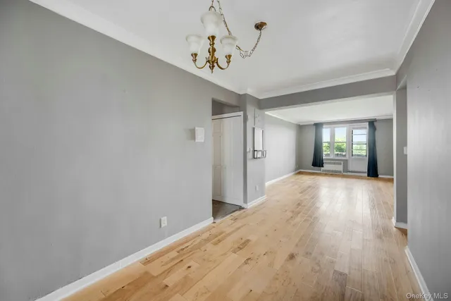a view of a hallway with wooden floor and a chandelier