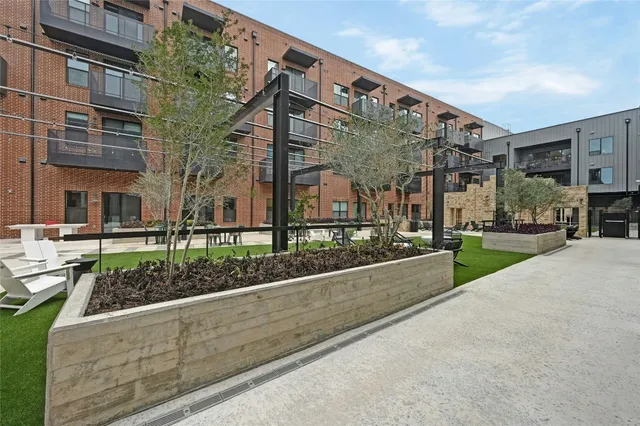 a view of a house with a yard and potted plants