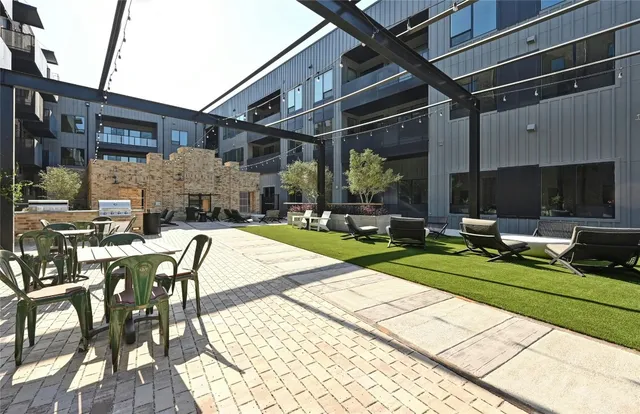 a view of a patio with table and chairs with wooden floor and fence