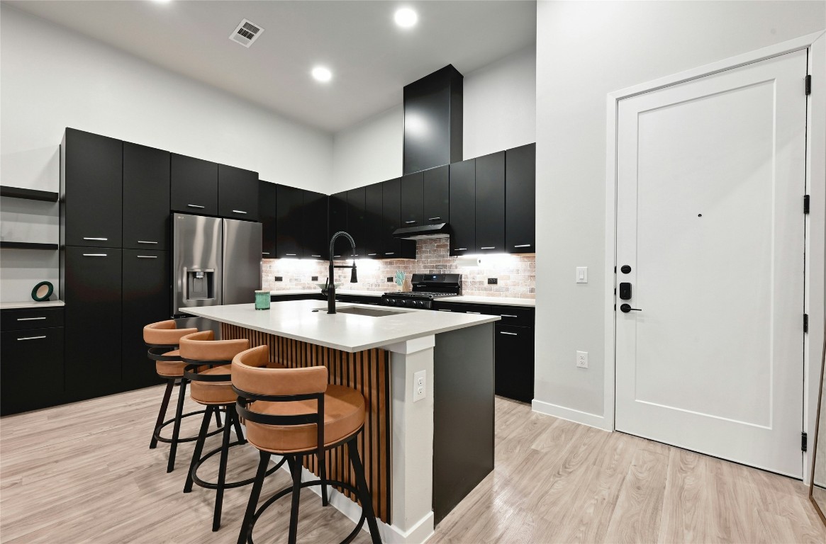 4510 Terry-O Lane, Unit 138 Austin, TX 78745 - Photo 3 of 40 a kitchen with stainless steel appliances kitchen island granite countertop a sink cabinets and wooden floor
