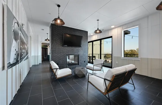 a living room with furniture a flat screen tv and a fireplace