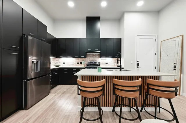 a kitchen with stainless steel appliances kitchen island granite countertop a refrigerator a stove a sink and a microwave