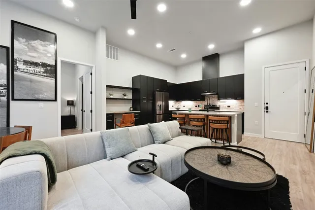 a living room with furniture and kitchen view
