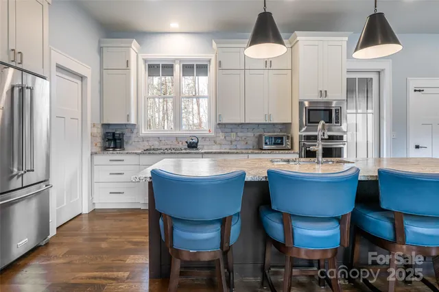 a kitchen with a table chairs sink and cabinets