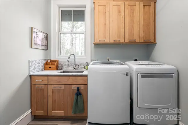 a utility room with sink dryer and washer
