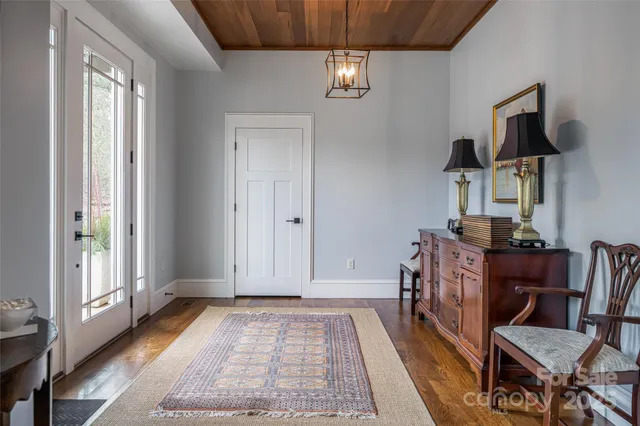 a view of hall way with furniture and chandelier