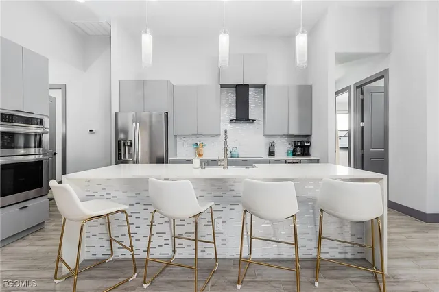 a kitchen with stainless steel appliances kitchen island granite countertop a kitchen island and chairs in it