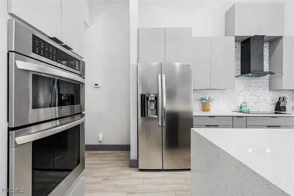 a kitchen with granite countertop a refrigerator oven and stainless steel appliances