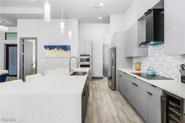a large kitchen with stainless steel appliances lots of counter space and wooden floor