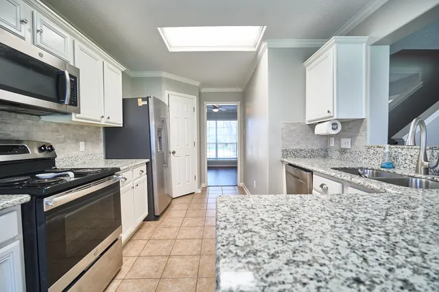 a kitchen with stainless steel appliances granite countertop a stove a sink and a microwave