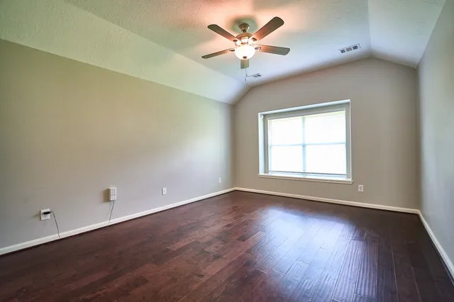 an empty room with wooden floor and window