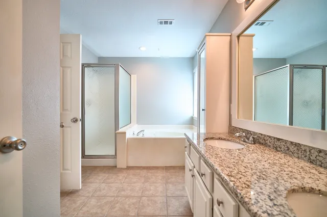 a spacious bathroom with a granite countertop tub sink and mirror