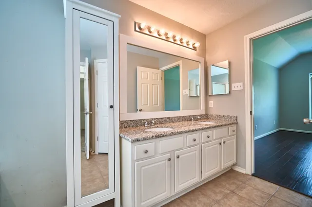 a bathroom with a granite countertop sink and a mirror