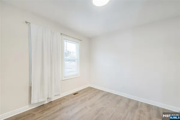 an empty room with wooden floor and window