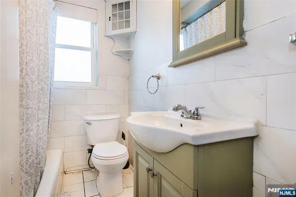 a bathroom with a sink a toilet and mirror