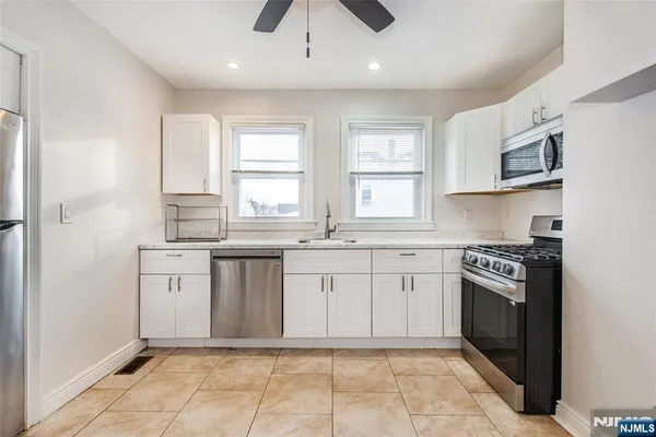 a kitchen with stainless steel appliances granite countertop a stove a sink and a refrigerator