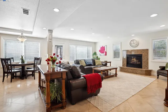 a living room with furniture a fireplace and a flat screen tv