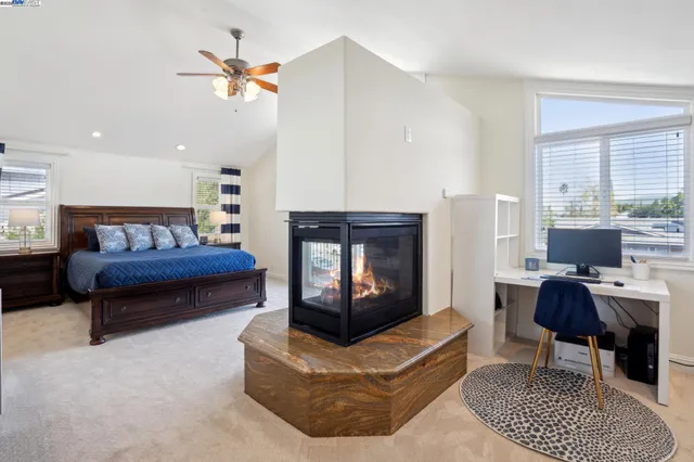 a spacious bedroom with a large bed and a fireplace