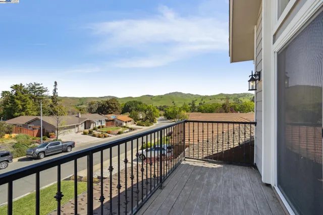 a view of a balcony with wooden floor and fence