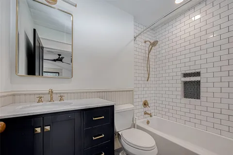 a bathroom with a sink a toilet a mirror and shower