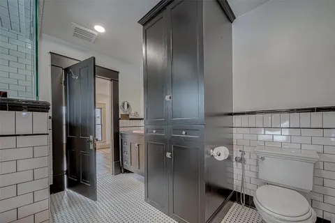 a view of a brick house with a small yard and wooden fence