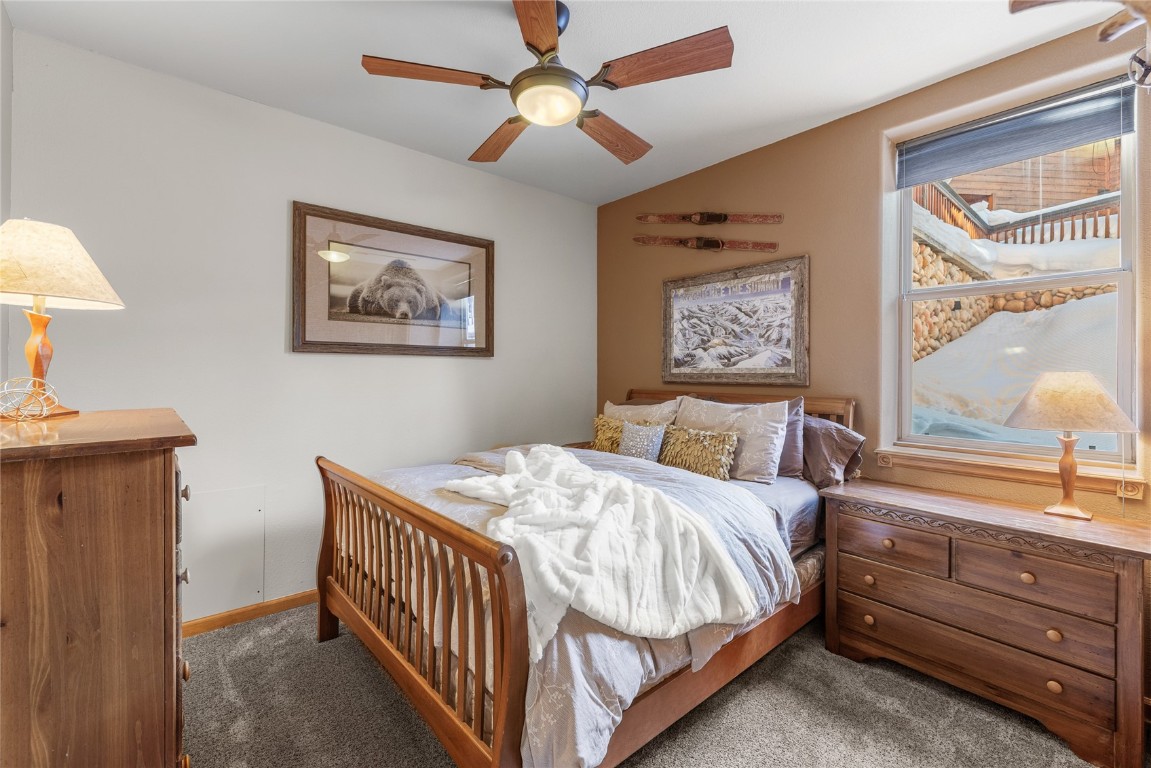 83 Lookout Ridge Drive, Unit 83 Dillon, CO 80435 - Photo 16 of 25 a bedroom with a bed and a chandelier