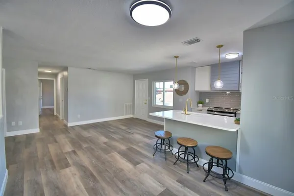 a kitchen with a sink a counter space and wooden floor