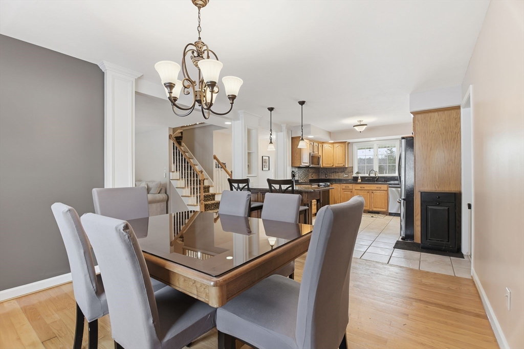 2 John Mason Road Southwick, MA 01077 - Photo 11 of 41 a dining room with wooden floor a chandelier a wooden table and chairs