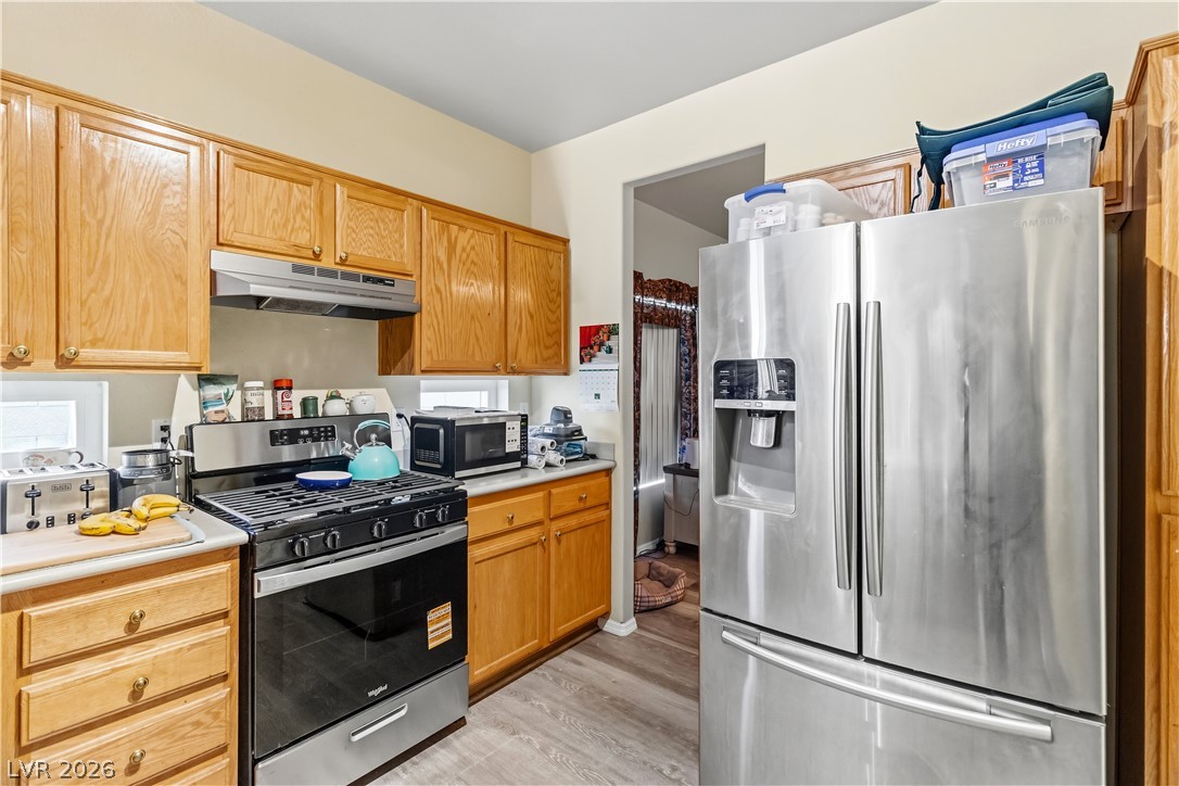 2823 Rippling Springs Street Laughlin, NV 89029 - Photo 12 of 89 Kitchen with stainless steel appliances, light countertops, and light wood-type flooring