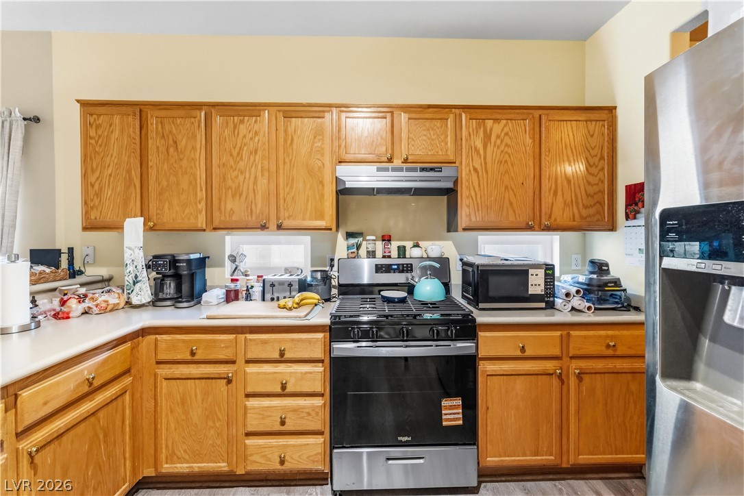 2823 Rippling Springs Street Laughlin, NV 89029 - Photo 13 of 89 Kitchen with stainless steel appliances, light countertops, and wood finish cabinets