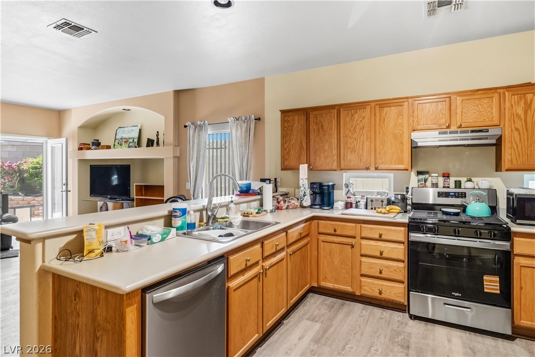 2823 Rippling Springs Street Laughlin, NV 89029 - Photo 15 of 89 Kitchen featuring stainless steel appliances, light countertops, a peninsula, and plenty of natural light