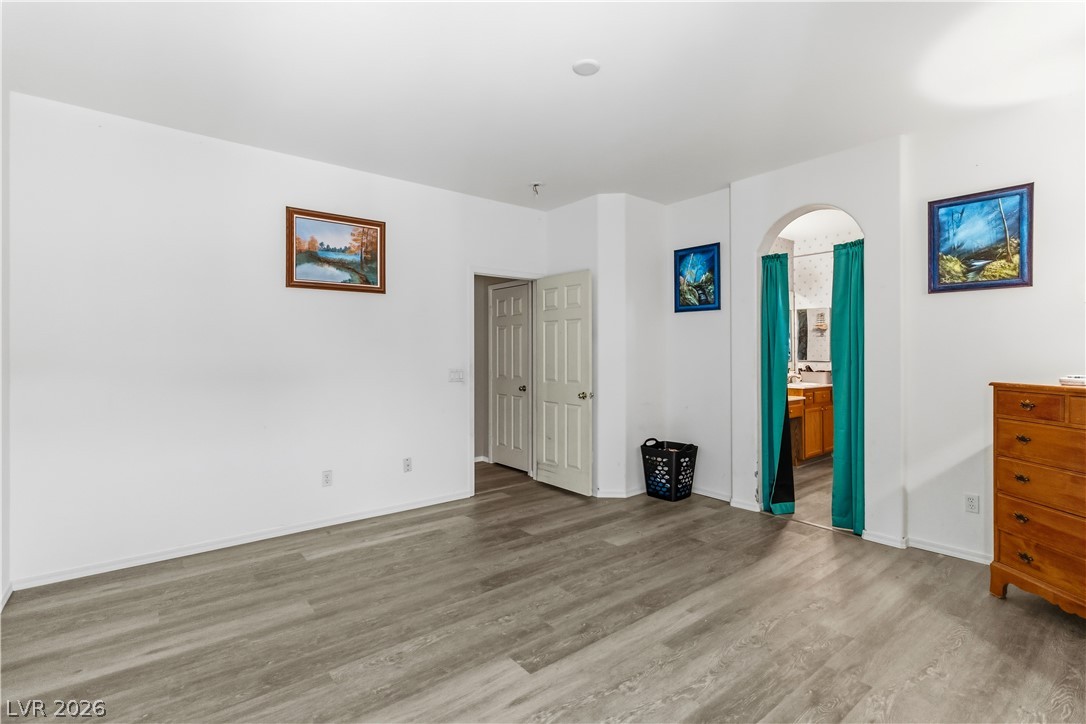 2823 Rippling Springs Street Laughlin, NV 89029 - Photo 29 of 89 Primary bedroom featuring arched walkways, wood finished floors, and ensuite bathroom