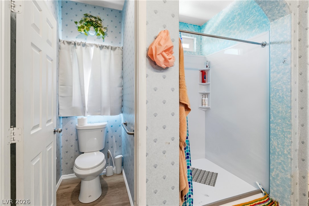 2823 Rippling Springs Street Laughlin, NV 89029 - Photo 34 of 89 Full Primary Bathroom with water closet, featuring wallpapered walls, and wood style floors
